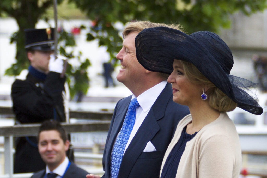 the queen and king of the Netherlands in a suit and tie